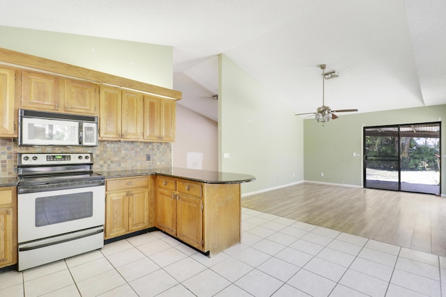 kitchen featuring ceiling fan, backsplash, vaulted ceiling, stainless steel electric range, and white microwave