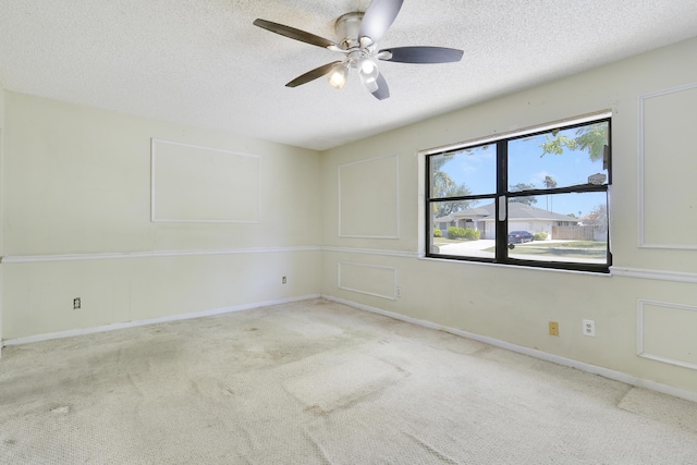 empty room featuring carpet flooring, a ceiling fan, a textured ceiling, and baseboards