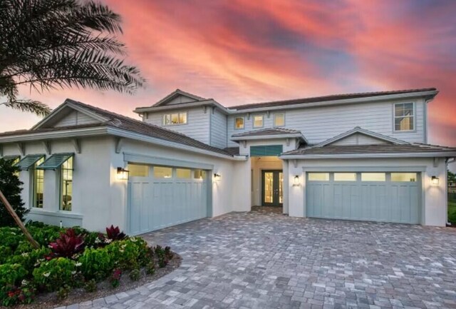 20136 Se Bridgewater Drive Livingston Model, Jupiter, FL 33458 - view of front of property featuring a garage, stucco siding, decorative driveway, and french doors