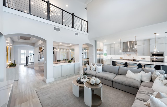20136 Se Bridgewater Drive Livingston Model, Jupiter, FL 33458 - living room featuring arched walkways, visible vents, an inviting chandelier, and a towering ceiling