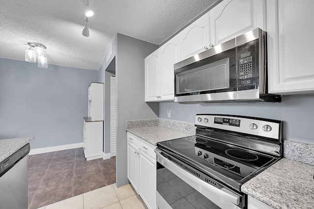1625 Meadows Cir W, Boynton Beach, FL 33436 - kitchen with appliances with stainless steel finishes, a textured ceiling, white cabinets, tile patterned flooring, and baseboards