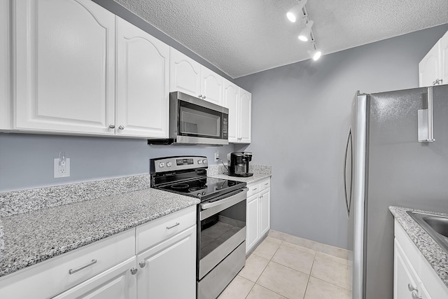 1625 Meadows Cir W, Boynton Beach, FL 33436 - kitchen with stainless steel appliances, a textured ceiling, white cabinetry, light stone countertops, and light tile patterned floors