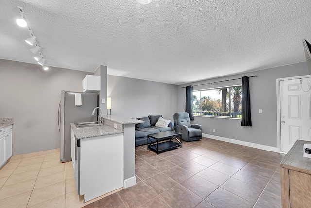 1625 Meadows Cir W, Boynton Beach, FL 33436 - kitchen featuring a peninsula, white cabinets, track lighting, open floor plan, and a sink