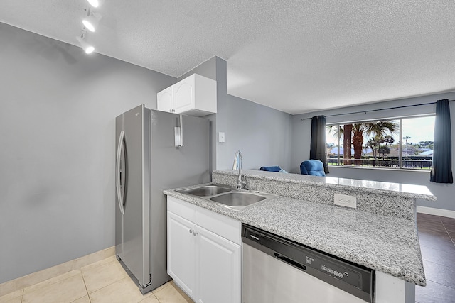 1625 Meadows Cir W, Boynton Beach, FL 33436 - kitchen with appliances with stainless steel finishes, a sink, a peninsula, light tile patterned floors, and a textured ceiling