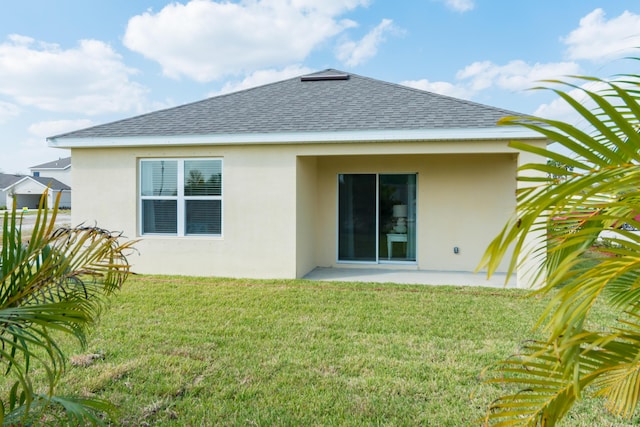 12134 SW Rimini Way, Port Saint Lucie, FL 34987 - back of property featuring stucco siding, roof with shingles, a patio area, and a yard