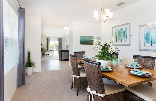 12134 SW Rimini Way, Port Saint Lucie, FL 34987 - carpeted dining room with visible vents, tile patterned floors, and a notable chandelier