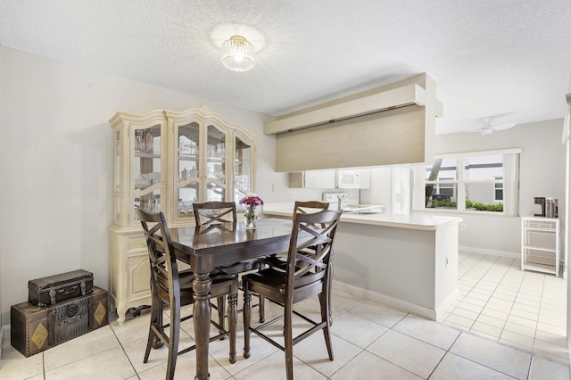 dining space with a textured ceiling and light tile patterned floors