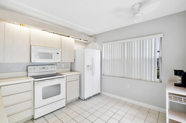 kitchen with ceiling fan, light countertops, baseboards, light tile patterned floors, and white appliances