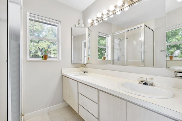 bathroom with a sink, tile patterned floors, a shower stall, and double vanity