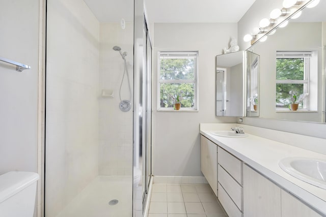 full bathroom featuring double vanity, toilet, tile patterned floors, a shower stall, and a sink