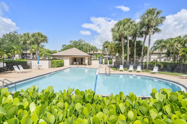 community pool with a patio and fence