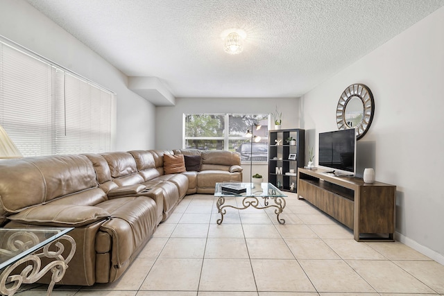 living room featuring light tile patterned flooring, a textured ceiling, and baseboards