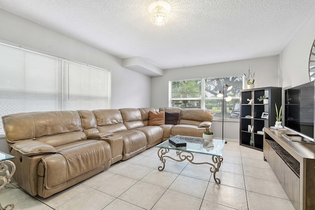 living room with a textured ceiling and light tile patterned floors