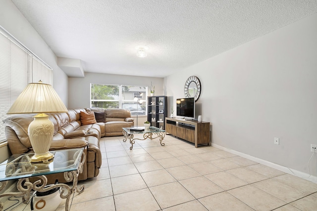 living area with baseboards, a textured ceiling, and light tile patterned flooring