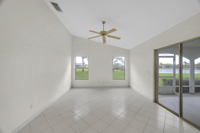 empty room featuring visible vents, baseboards, a water view, a ceiling fan, and light tile patterned floors
