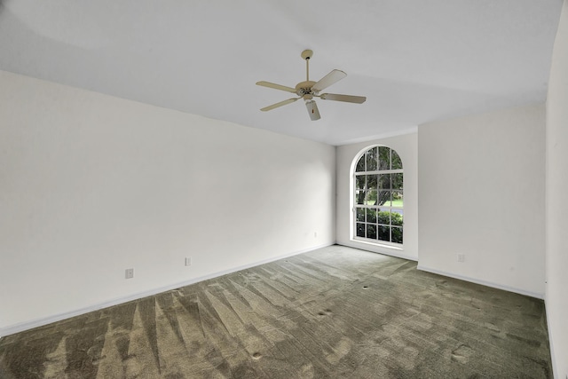 carpeted spare room with baseboards and ceiling fan