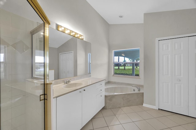 full bathroom featuring a closet, tile patterned flooring, a garden tub, and a stall shower