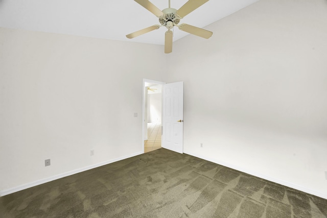 carpeted spare room featuring vaulted ceiling, baseboards, and a ceiling fan