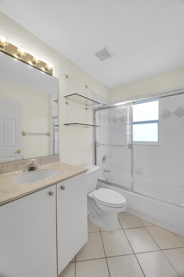full bathroom with visible vents, vanity, toilet, tile patterned floors, and combined bath / shower with glass door