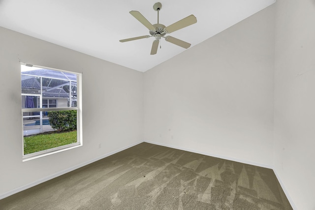 carpeted empty room featuring baseboards, ceiling fan, and vaulted ceiling
