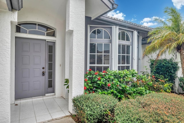 doorway to property featuring stucco siding