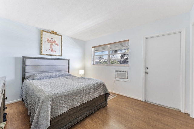 2520 S Federal Hwy Unit 14, Boynton Beach, FL 33435 - bedroom with baseboards, a wall unit AC, and wood finished floors