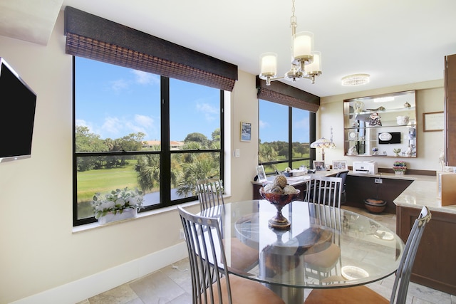 dining area featuring an inviting chandelier and baseboards