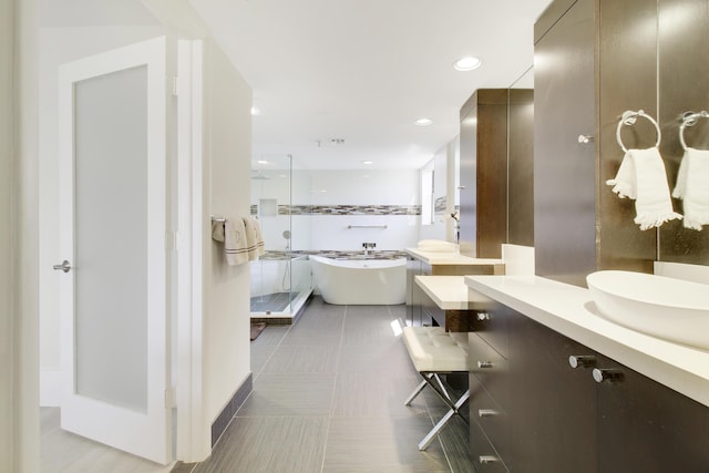 bathroom with recessed lighting, a freestanding tub, a shower stall, and vanity