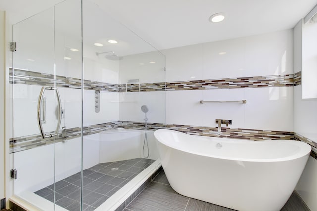 full bath with a stall shower, tile walls, recessed lighting, and a freestanding bath