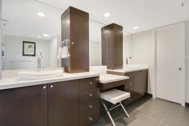 bathroom with recessed lighting, a sink, and two vanities