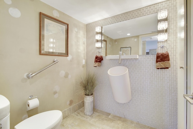 bathroom featuring tile walls and toilet