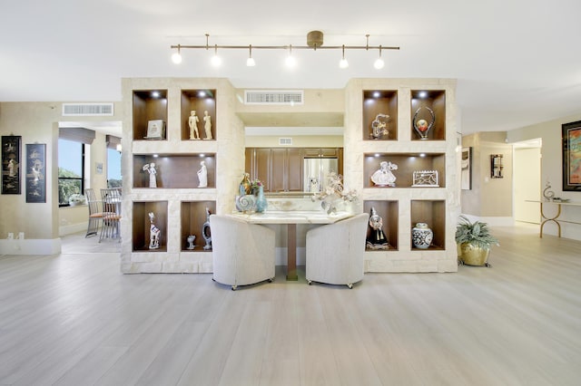 living area with visible vents and wood finished floors
