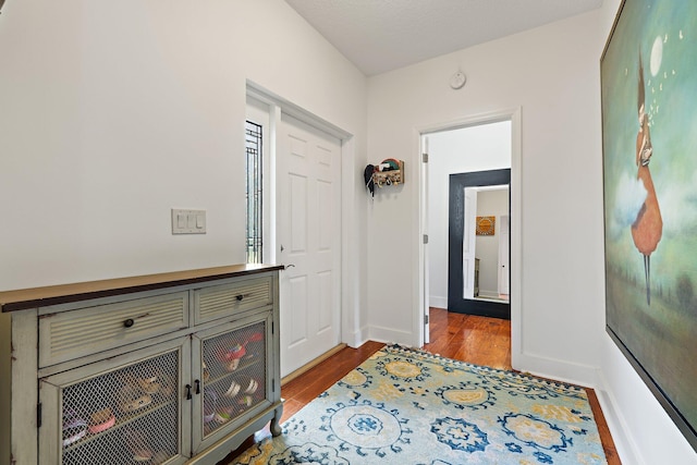 hallway with baseboards and wood finished floors
