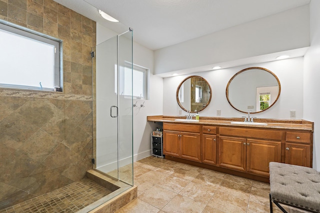 bathroom with plenty of natural light, a sink, and a shower stall