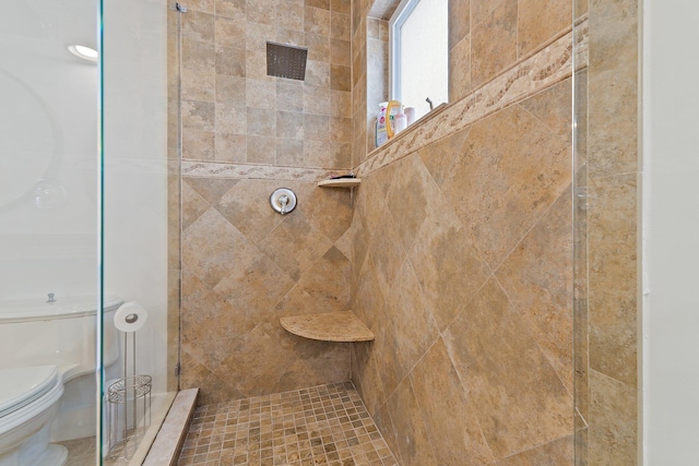 bathroom featuring toilet and tiled shower
