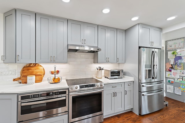 kitchen featuring gray cabinetry, appliances with stainless steel finishes, under cabinet range hood, and a toaster