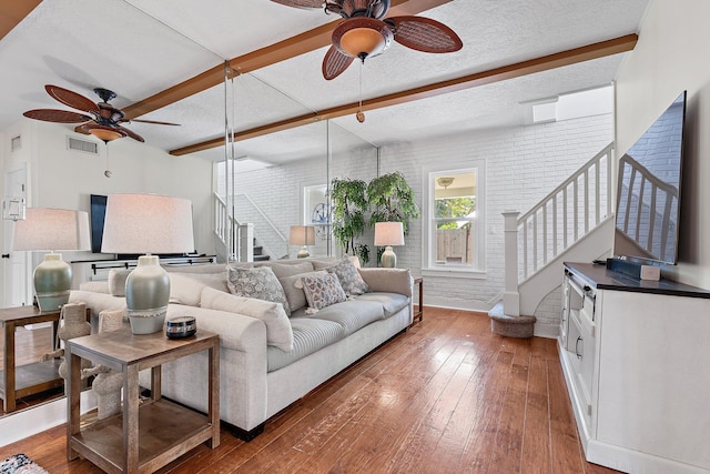 living room featuring ceiling fan, wood-type flooring, stairs, and visible vents