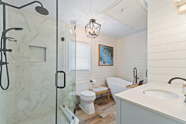 full bath with vanity, a freestanding tub, wood finished floors, toilet, and a stall shower