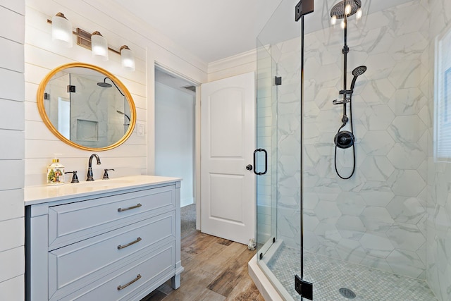 bathroom featuring crown molding, a marble finish shower, vanity, and wood finished floors
