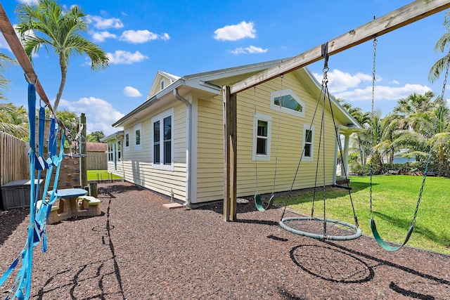 view of side of property with fence and a yard