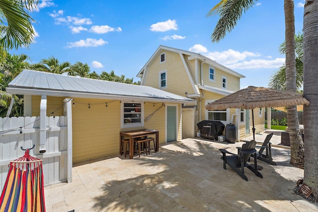 view of patio featuring fence, an outbuilding, and area for grilling