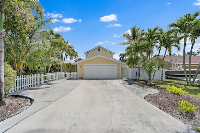 view of front of property featuring fence, an attached garage, and driveway