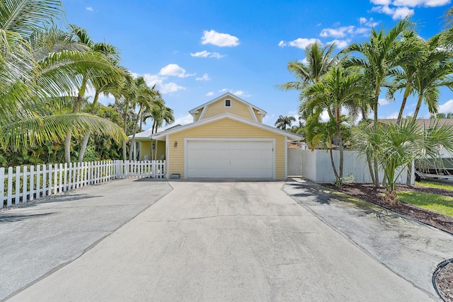 view of front facade featuring fence, an attached garage, and driveway