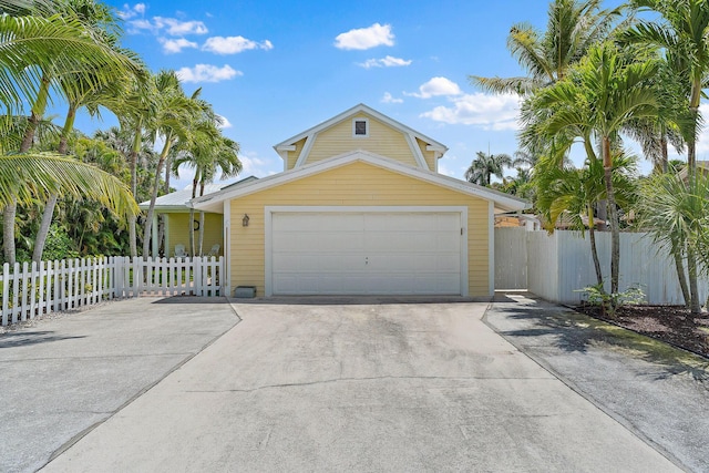 view of front of property with an attached garage, fence, and driveway