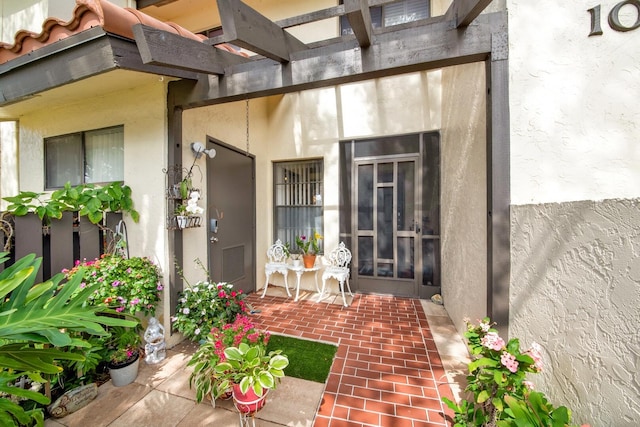 entrance to property with a patio and stucco siding