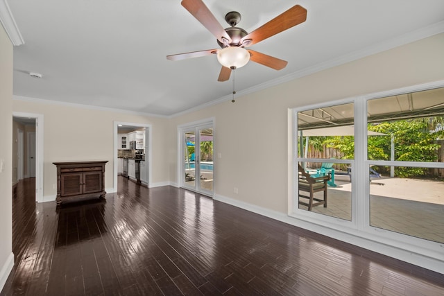 unfurnished living room with crown molding, baseboards, wood finished floors, and a ceiling fan