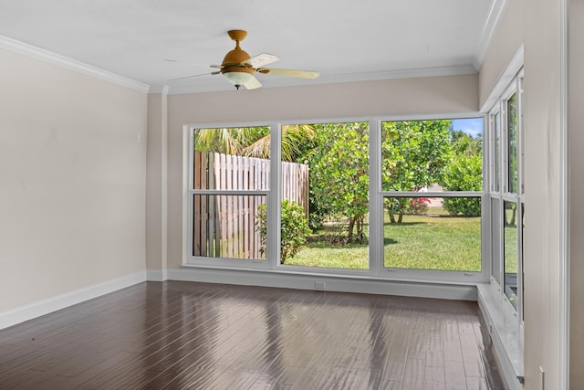 unfurnished room featuring ornamental molding, healthy amount of natural light, wood finished floors, baseboards, and ceiling fan
