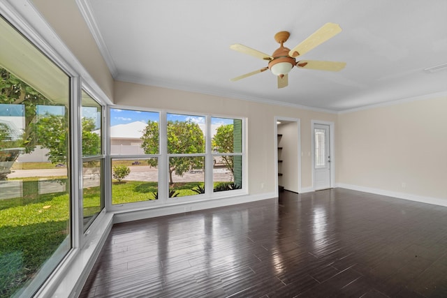 spare room featuring baseboards, ceiling fan, crown molding, and wood finished floors