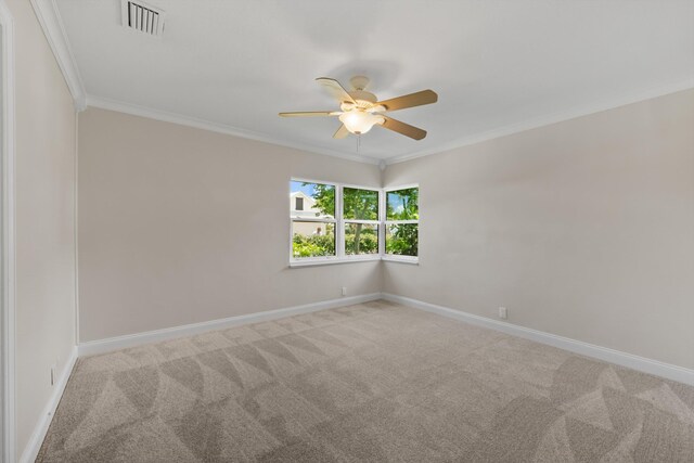 spare room featuring a ceiling fan, carpet flooring, crown molding, and baseboards