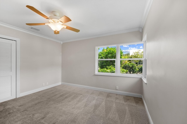 empty room with crown molding, baseboards, carpet flooring, and ceiling fan